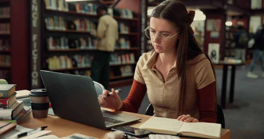 Laptop, woman and student with notebook in library studying for university exam with textbooks. Education, computer and female person writing with learning for college test or assignment on campus.