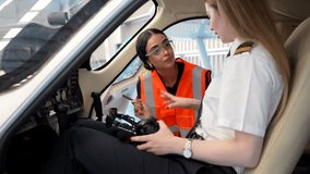 Female flight instructor explaining aircraft controls to a trainee pilot inside the cockpit of a small plane - Powered by Shutterstock - Get 15% off with code: PIKWIZARD15