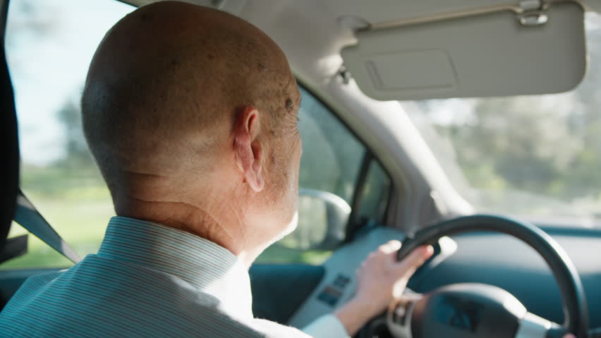 Elderly Man Driving the Car on a Sunny Day 