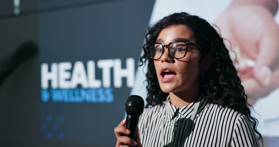 Business woman, presentation and health seminar with mic for wellness speech or awareness campaign. Female person, presenter or speaker for healthcare talkshow, medical convention or staff workshop