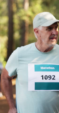 Marathon, man and running competition in forest for fitness challenge, sports event and stamina. Runner, mature person and cardio exercise outdoor for workout performance, endurance and pace training