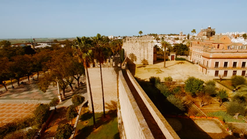 The Alcazar of Jerez de la Frontera in Andalucia frames medieval battlements and slender crenelated turrets against a clear sky, Jerez de la Frontera, Andalucia, Spain
