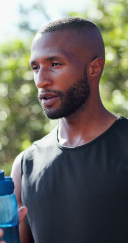 Fitness, drinking water and black man in park to rest for wellness, health and fresh air in nature. Sports, morning and person with liquid, minerals and hydration for workout, training and exercise