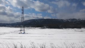 Winter Landscape: Snowy Field with Power Lines and Distant Mountains - Powered by Shutterstock - Get 15% off with code: PIKWIZARD15