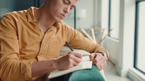 List, notebook and writing with man on sofa for inspiration, journal prompt and reminder. Reflection, agenda and planning with person in living room of home for diary, schedule and brainstorming - Powered by Shutterstock - Get 15% off with code: PIKWIZARD15