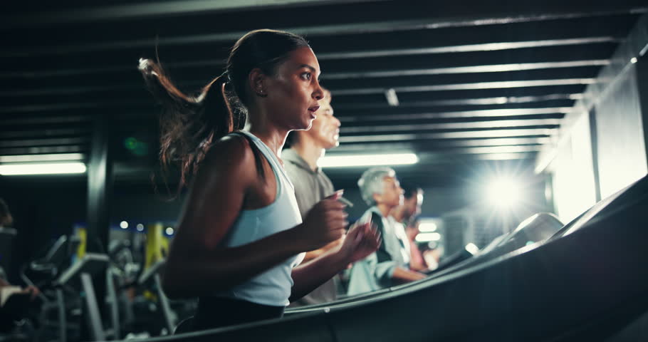 Woman, breathing and run on treadmill in gym for fitness, endurance and intense workout with sweating. Race training, practice or serious female runner with machine, exercise and cardio at night