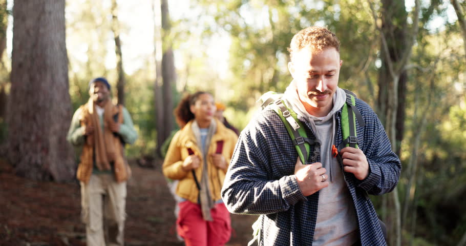 Hiking, man and friends with walking in woods for travel adventure, sightseeing and fresh air. Backpacker, hobby and group with backpack in forest for holiday journey, weekend break or explore nature