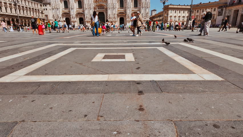 MILAN, Italy, 16 JULY 2024 - Busy cathedral square framed by the ornate facade of the Duomo di Milano and surrounding historic arcades, Milan, Lombardy, Italy
