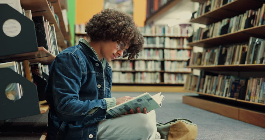 Student, man and reading a book in library for exam preparation, study insight and test knowledge. College, person and course resources on floor with thesis citation, research solution and education