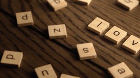 Wooden letter tiles form the word love as the camera pans smoothly across a wooden surface. - Powered by Shutterstock - Get 15% off with code: PIKWIZARD15