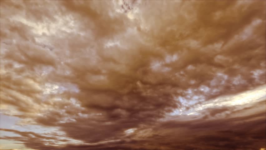 timelapse clip of heavy dramatical dirty orange snow or rain clouds