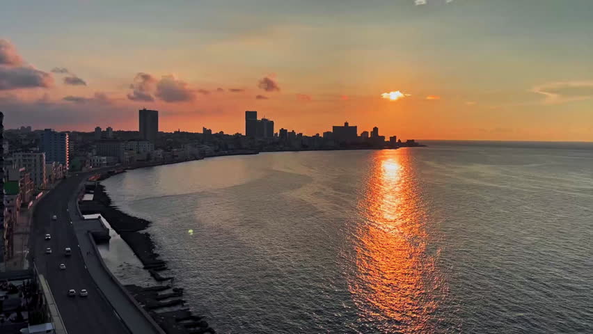 Cityscape at sunset with cars on the avenue in Havana, Cuba.