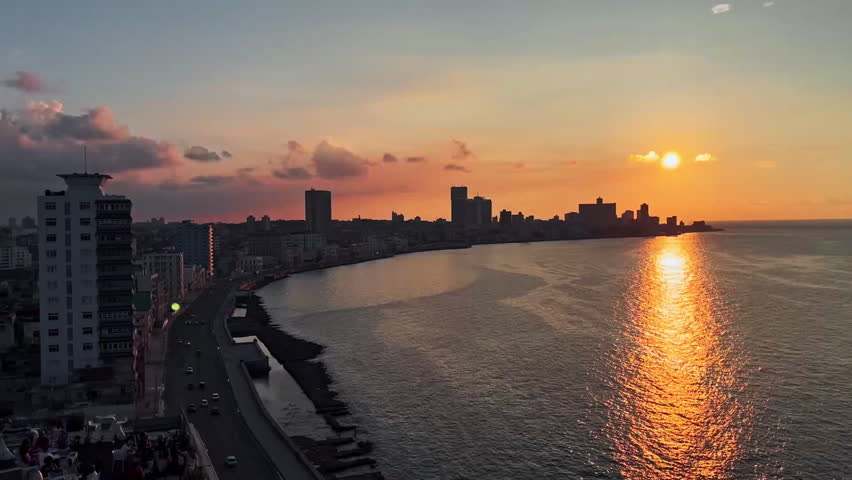 Sunset in Havana, Cuba with buildings and rooftop on the left.