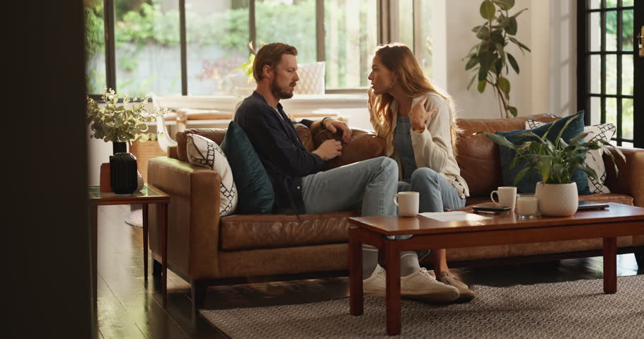 Frustrated couple, conflict or home with fight on sofa for argument, divorce or cheating affair. Upset, man or woman shouting with disagreement or dispute for blame, toxic relationship or breakup