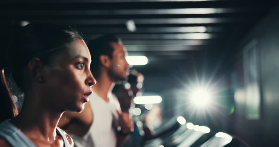 Woman, breathing and running on treadmill in gym for fitness, endurance and intense workout with sweating. Race training, practice or serious female runner with machine for exercise and cardio