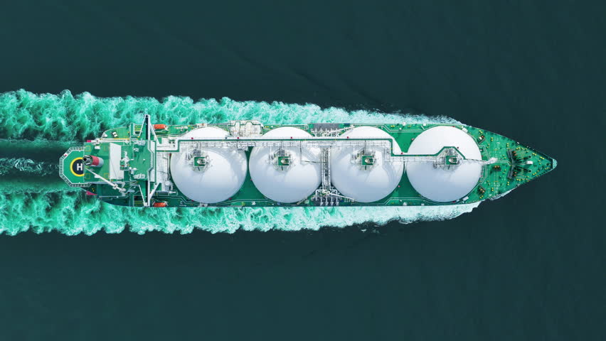 Aerial top view LNG Tanker ship (Liquified Natural Gas) with contrail in the ocean sea ship carrying container and running for export from container international port to custom ocean