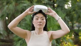 Woman putting on virtual reality goggles in a park - Powered by Shutterstock - Get 15% off with code: PIKWIZARD15