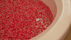 red rose petals float gently on calm water surface in spa bathtub during slowmotion moment creating relaxing ambiance for wellness and aromatherapy treatment with romantic natural fragrance - Powered by Shutterstock - Get 15% off with code: PIKWIZARD15