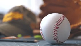 Close-up shot of a person's hand reaching to pick up a baseball placed on a desk - Powered by Shutterstock - Get 15% off with code: PIKWIZARD15