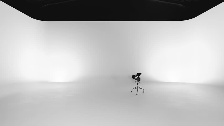 Empty photo studio undergoing lighting setup for professional photography or videography