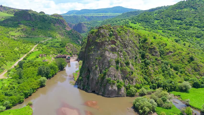 Aerial View of Scenic River Gorge with Lush Green Hills and Rocky Cliff