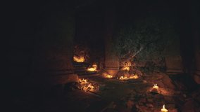 A dimly lit underground chamber features a rocky terrain adorned with scattered candles. Flickering lights create a haunting ambiance in this secluded space. - Powered by Shutterstock - Get 15% off with code: PIKWIZARD15