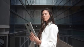 In a modern urban setting, a confident businesswoman holds a stateoftheart tablet, her professional attire showcasing her leadership and innovative spirit in the corporate world - Powered by Shutterstock - Get 15% off with code: PIKWIZARD15