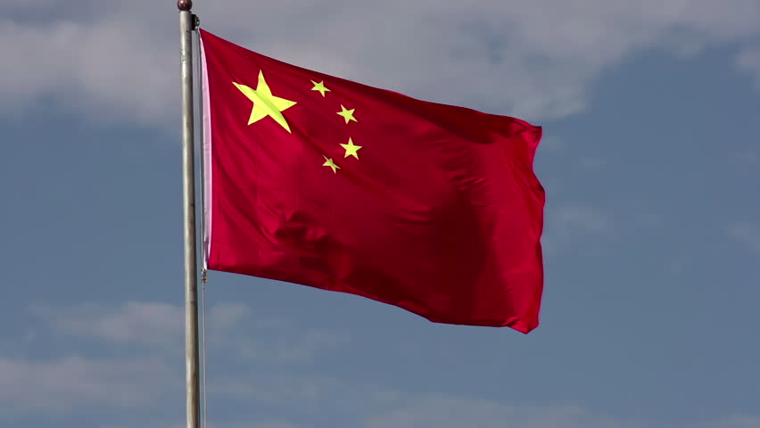 Flag of China. Flag of the People's Republic of China against the blue sky with white clouds. Slow Motion