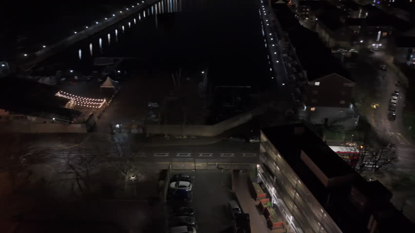 Aerial view following a double decker bus driving on the streets of London, night