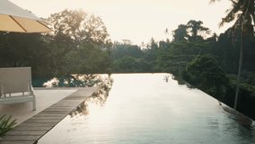 Infinity pool of a luxury villa in the highlands of Ubud, Bali with a misty rainforest view. Tall trees line the steep cliffs, creating a stunning and dramatic jungle backdrop. - Powered by Shutterstock - Get 15% off with code: PIKWIZARD15