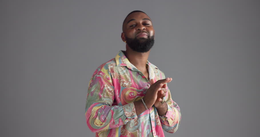 Black man, face and laughing with fashion in studio for bold indie style, bohemian aesthetic and confidence. Mockup space, person and happy in paisley shirt with attitude and pride on gray background