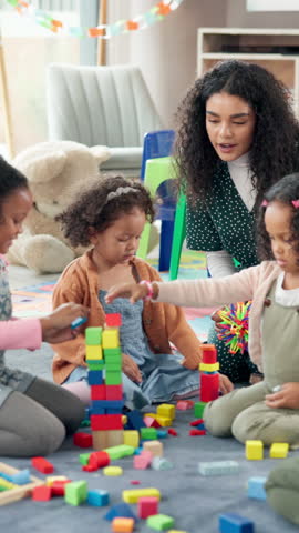 Building blocks, education and teacher with children in classroom for playtime in morning. Happy, students and educator helping kids with cognitive development, skills or growth at elementary school.
