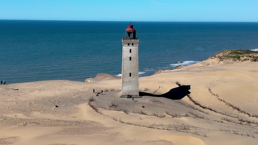 Discover the beauty of Rubjerg Knude Fyr Lighthouse in Jutland, Denmark, where sandy shores meet the stunning North Sea.