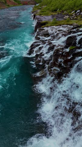 Witness the enchanting beauty of Barnafoss and Hraunfossar, where cascading waters flow over unique rock formations surrounded by lush greenery. Discover natures artistry in Iceland.