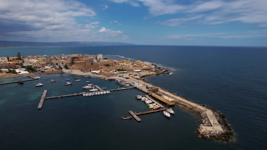 Aerial footage of Marzamemi, Sicily, Italy. Coastline with historic port, narrow streets, clear blue water