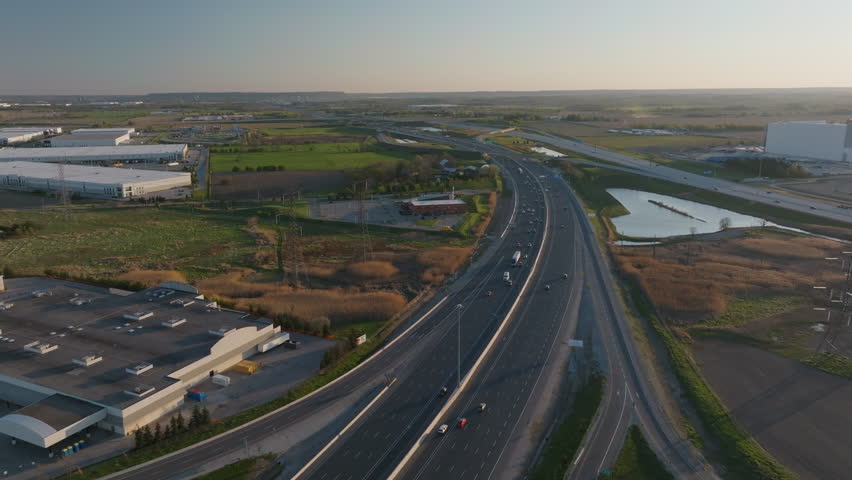 Highway 401 in mississauga, showcasing traffic and surrounding fields, aerial view