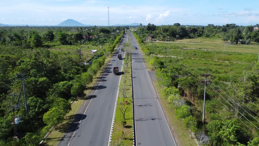 A convoy of trucks carrying rocks crossing the highway