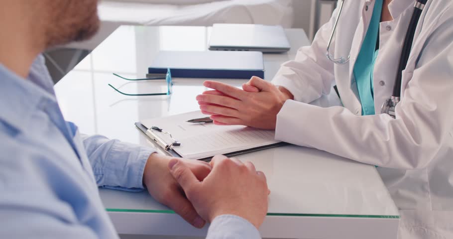 Cropped view of doctor and patient having discussion during medical consultation at clinic. Professional physician gesturing during conversation, talking about medical results after examination.
