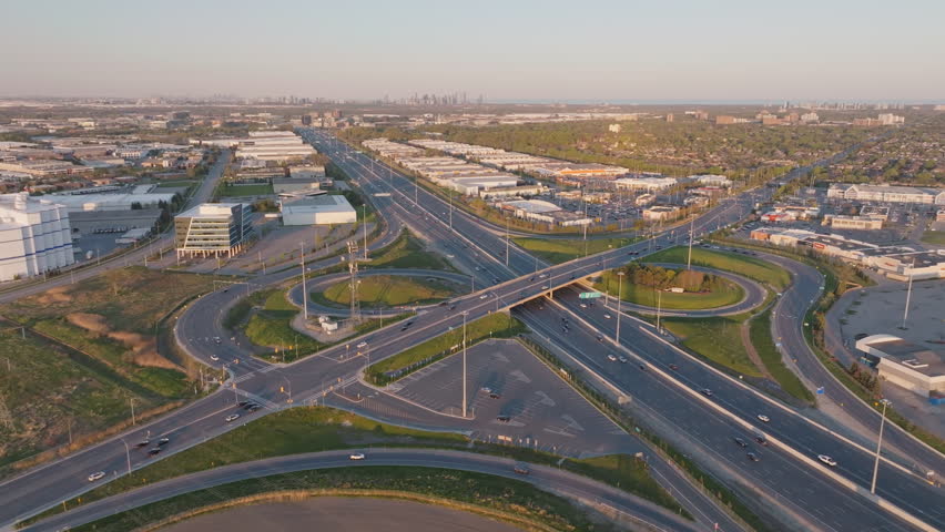 Wide aerial view of highway 401 in Mississauga, Canada, slow motion, capturing the bustling roads and surrounding industrial buildings