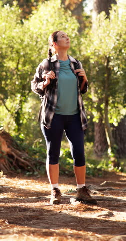 Hiking, travel and woman in woods for thinking, sightseeing and idea for adventure. Trekking, backpacking and person in forest for vacation, holiday and exploration with reflection for eco tourism