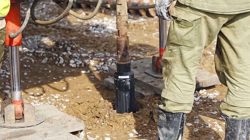 Close-up of soil sampling during pile drilling process. Extraction of subsurface material for geotechnical analysis and foundation assessment. High quality 4k footage