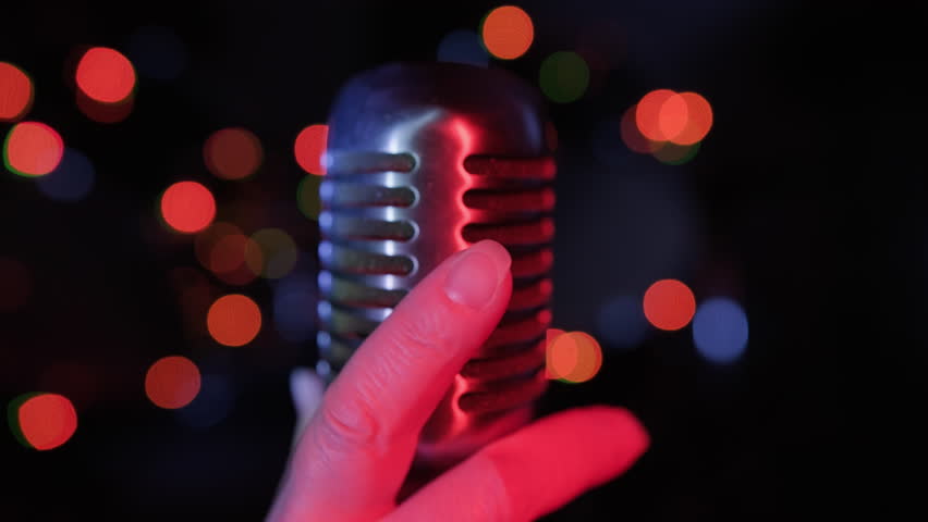 Singer hand taking retro vintage microphone on stage close up. Start of performance.