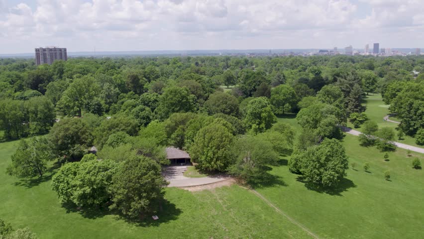 Drone shot of Cherokee Park in Louisville, Kentucky, with the downtown skyline visible in the distance. Great for nature, urban lifestyle, and regional content.