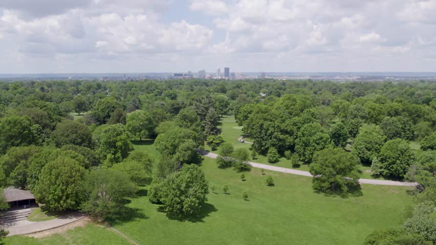 Aerial view of Cherokee Park in Louisville, Kentucky, with the downtown skyline visible in the distance. Great for travel, cityscape, and outdoor lifestyle content.