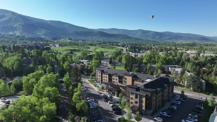 A drone drifts over Steamboat Springs Colorado in the early morning of June1 2025 with a hot air balloon in the distance.