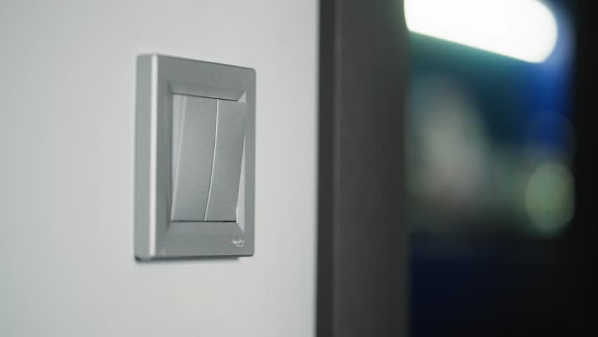 Turning on the light in the room. Close-up of a hand turning on the light with a switch. High quality 4k footage