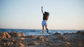 Slow motion video of a woman running on stones on the beach near the ocean. Fitness and sport in a seascape. - Powered by Shutterstock - Get 15% off with code: PIKWIZARD15
