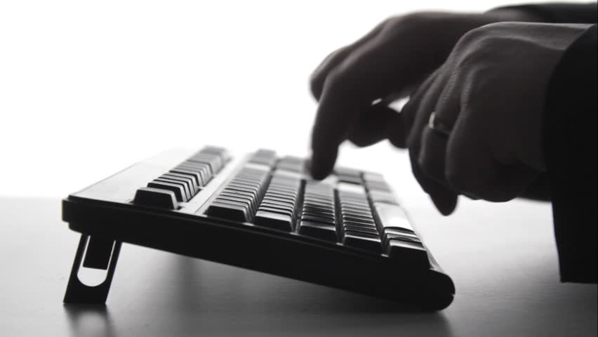 Silhouette of man using computer keyboard