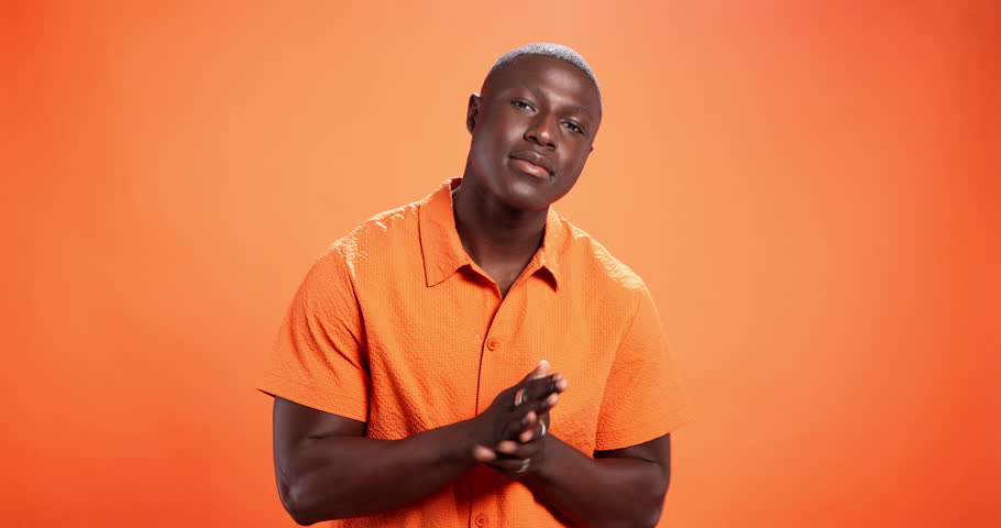 Face, black man and pride for fashion in studio background, trendy clothes and bold indie style. Portrait, mockup space and person with arms crossed for bohemian aesthetic, orange shirt and attitude