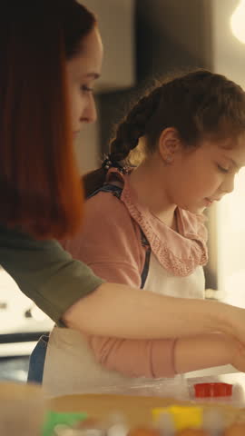 Little girl and her mom baking together, using cookie cutter, homemade recipe
